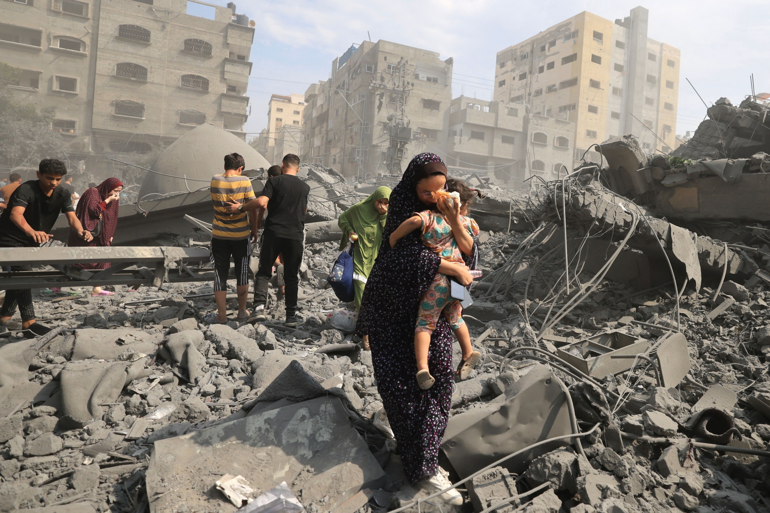 Palestinians evacuate the area following an Israeli airstrike on the Sousi mosque in Gaza City on October 9, 2023.