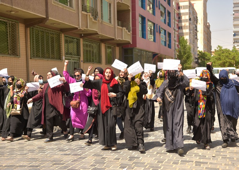 Women march in the street holding placards.