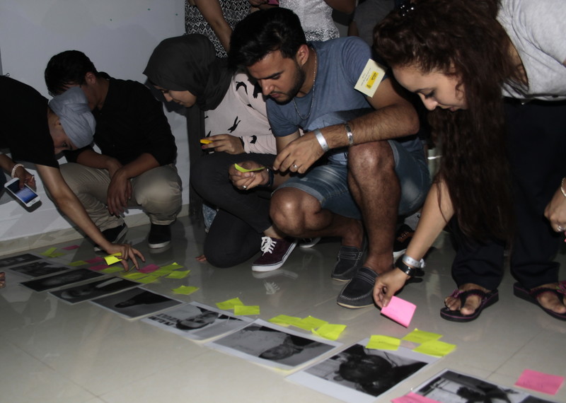 مشاركون يقارنون انطباعاتهم مع الصور المرفقة في تمرين يهدف إلى الكشف عن الأفكار المتحيزة. الحمامات، تونس، يوليو/تموز 2016 © Amnesty International