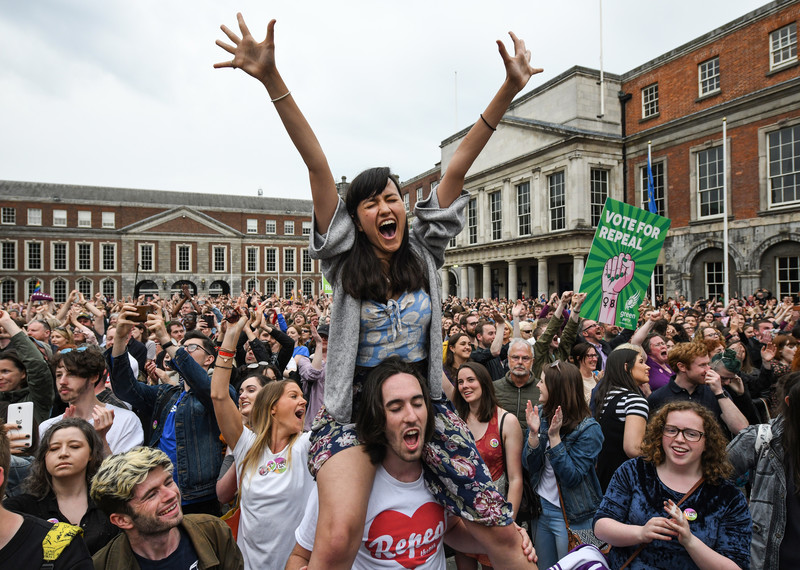 امرأة ترفع ذراعيها تعبيراً عن الانتصار في مظاهرة احتفال بتصويت أيرلندا لصالح قانون الإصلاح في الاستفتاء على الإجهاض. © Jeff J Mitchell/Getty Images