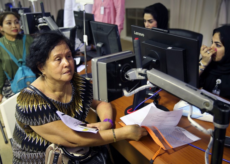 عاملات فيليبينيات يفحصن عيونهن في مركز لاصدار التأشيرات في العوير، على بعد 30 كم شرقي دبي في دولة الإمارات العربية المتحدة، في 1 أغسطس/آب 2018. © كامران جبريلي / أ.ب. / ريكس / شاترستوك