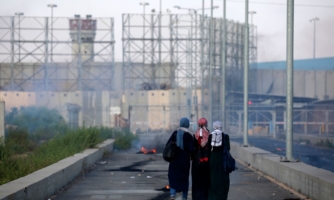 Palestinian protestors walk towards the borde