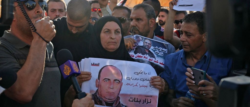 The mother of Palestinian political activist Nizar Banat carries his portrait during a rally in Ramallah city in the occupied West Bank on July 3, 2021.