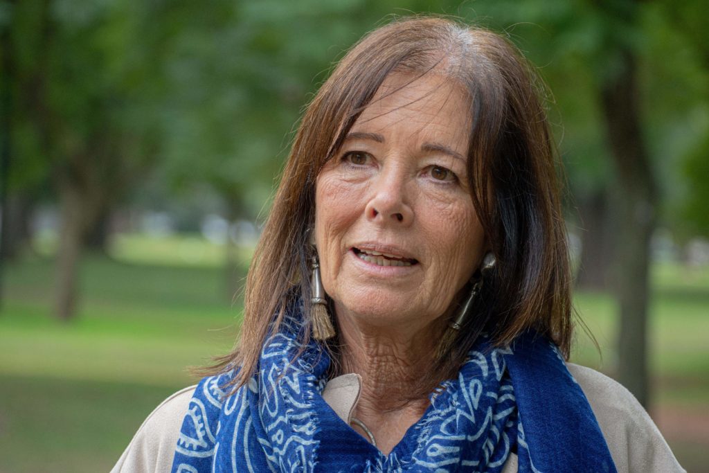 Susana from Argentina. She is wearing a blue scarf and decorative earrings.