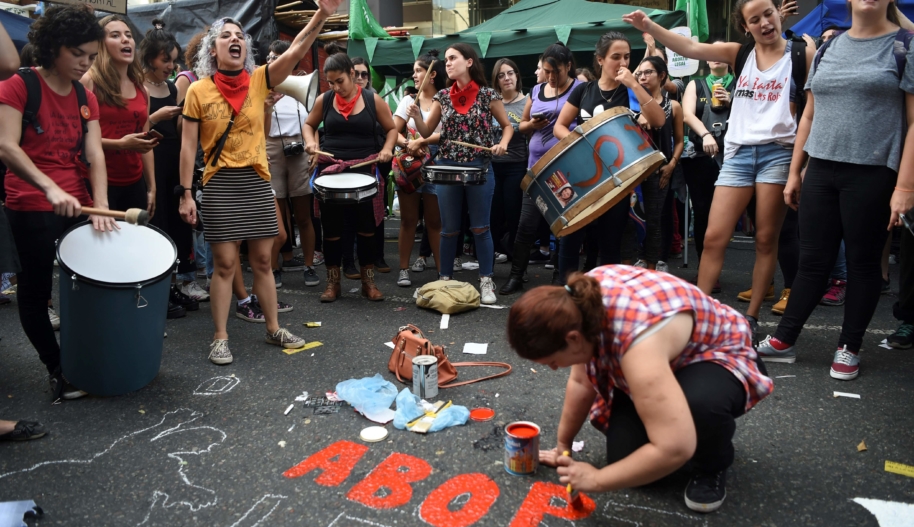 A demonstrator paints a legend on the street in demand of women’s access to safe, free and legal abortion, during a rally outside the National Congress in Buenos Aires, on April 10, 2018.