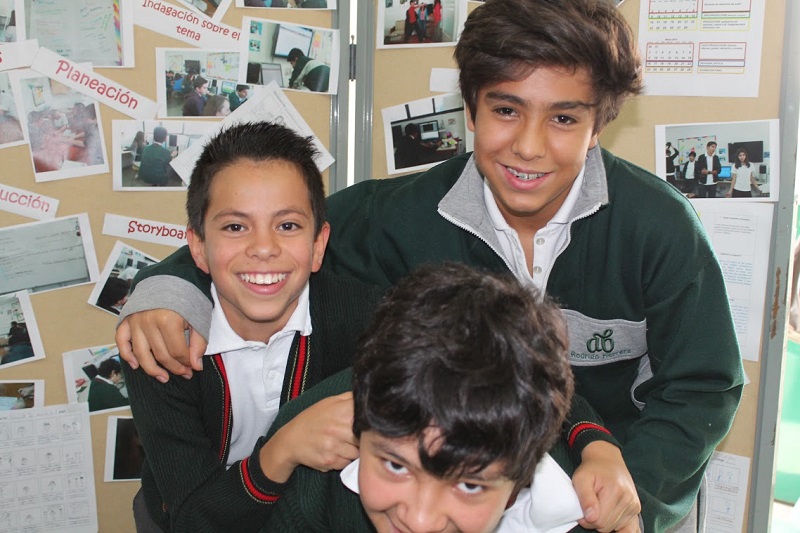 Students Diego Garza, Rodrigo Herrera and Santiago Villalobos pose in front of the photo exhibition of the Short Film Festival on Gender Equality which took place in Colegio Alexander Bain primary school. Mexico, 22 May 2014. ©Amnesty International Mexico.