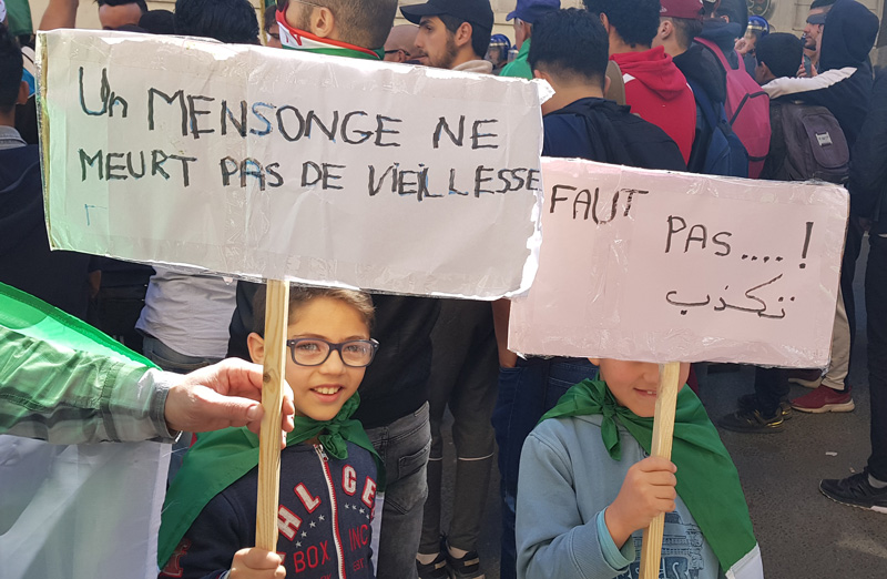 Children participating in the 15 March 2019 protest in Algeria carry signs that say: 