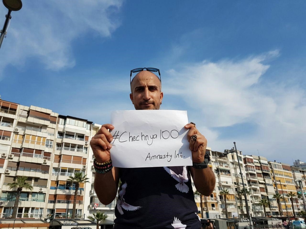 An Amnesty International activist in Turkey holds up a sign for Chechnya to mark the International Day Against Homophobia, Transphobia and Biphobia on 3 June