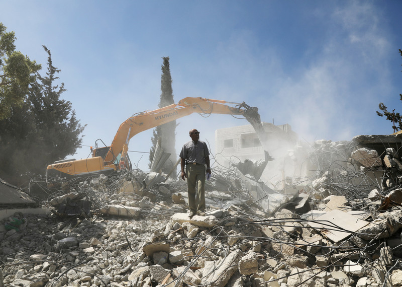 Palestinian Jihad Shawamrah stands on the ruins of his house, which he demolished in order not to face the prospect of Israeli settlers moving in, after he lost a land
ownership case in Israeli courts, in the East Jerusalem neighbourhood of Beit Hanina, 19 July 2018. © Reuters/Ammar Awad