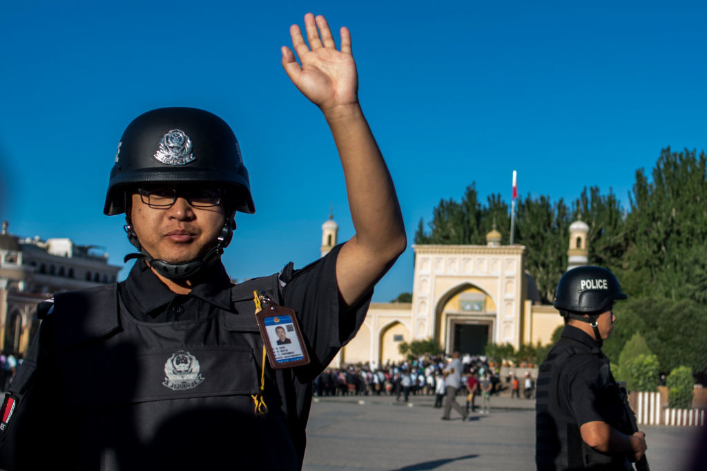 A policeman gestures as Muslims arrive at for  morning prayer in China's Xinjiang Uighur Autonomous Region.