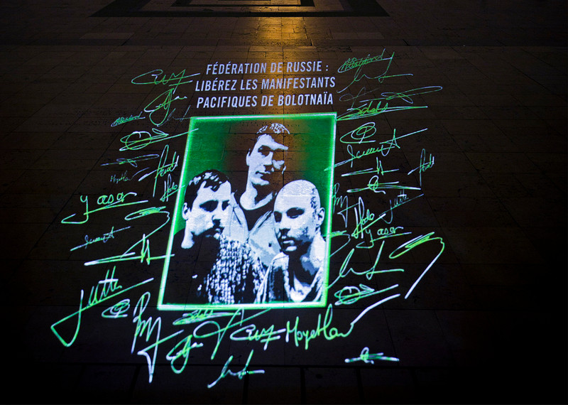 An image of three people featured in Write for Rights is projected onto the Le Parvis des droits de l'homme in Paris, France, in December 2013. © Pierre-Yves Brunaud/Picturetank pour Amnesty International
