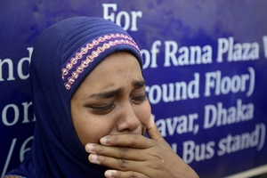 A Bangladeshi mourner and relative of a victim of the Rana Plaza building collapse weeps as she takes part in a protest marking the first anniversary of the disaster. © MUNIR UZ ZAMAN/AFP/Getty Images