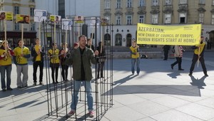 A caged activist at a protest in Vienna symbolizes the many prisoners of conscience still detained in Azerbaijan, May 2014. © Amnesty International