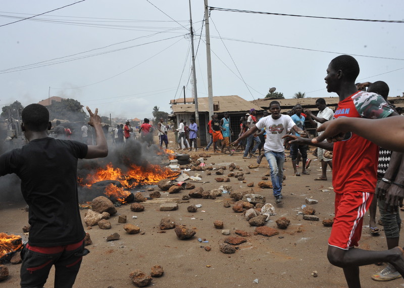Demonstrators setting-up a road block with burning tyres and rocks in Bomboli, Conakry, on 13 April 2015.