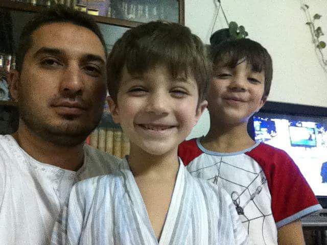 Mohammed Issam Zaghloul with his two sons, Saryah and Zaid, June 2011, at home in Daraya, Syria.