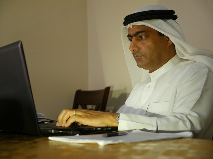 Ahmad Mansoor sitting at a laptop