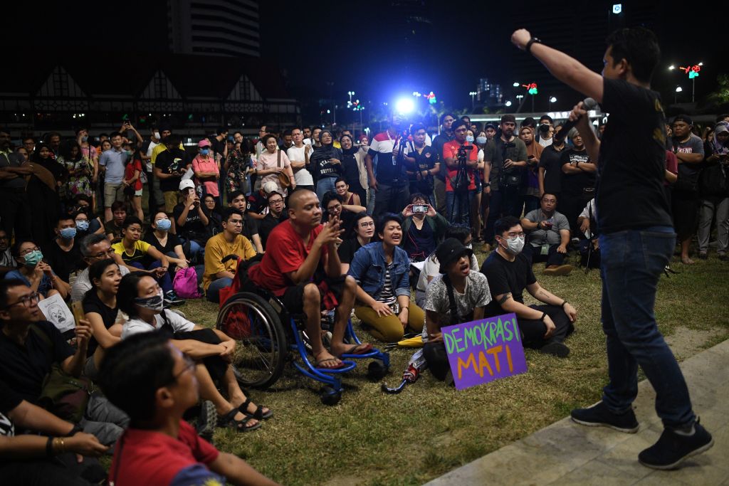People listen to a speaker during a demonstration in Kuala Lumpur on February 29, 2020, after Muhyiddin Yassin was appointed as Malaysia's next prime minister by the king following the collapse of a reformist ruling coalition last week.