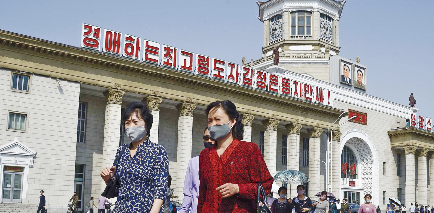 People wearing face masks walk in front of Pyongyang Station on June 6, 2020, amid the global spread of the novel coronavirus.