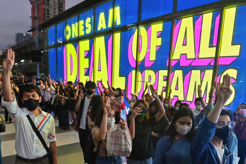 Pro-democracy protesters give the three-finger salute outside the Siam Paragon shopping centre in Bangkok on October 20, 2020.