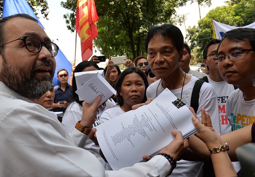 Philippine environmental activists lead by climate campaigner Yeb Sano (R) hand over documents calling for an investigation into fossil fuel companies over climate change to Human Rights Commission officials outside their office in Manila on September 22, 2015. The activists are calling for an investigation into the top 50 investor-owned fossil fuel companies over climate change impact on people and their livelihoods.