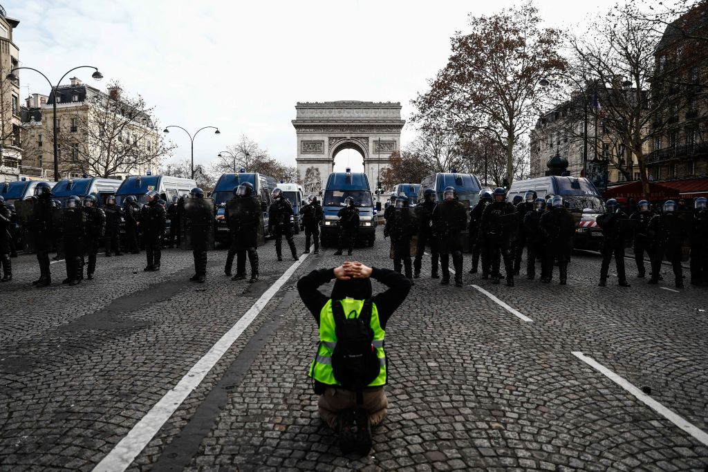 Riot police face off a Gilets Jaunes protestor in Paris, France.