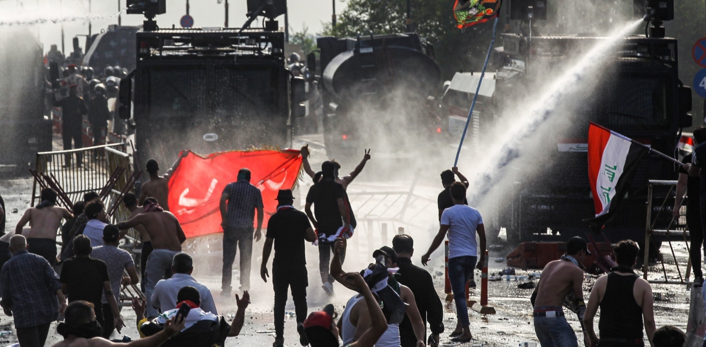Protesters clash with Iraqi riot police vehicles firing water cannon during a demonstration against state corruption and poor services, between the capital Baghdad's Tahrir Square and the high-security Green Zone district, on October 1, 2019.