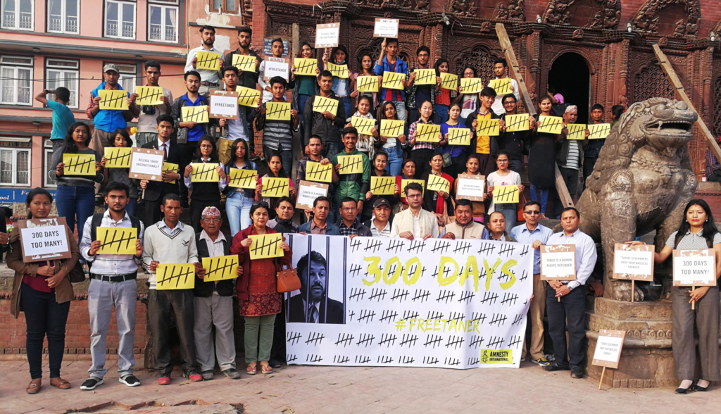 Amnesty in Nepal shared this photo on social media, with dozens of people holding placards with tally marks and #FreeTaner.