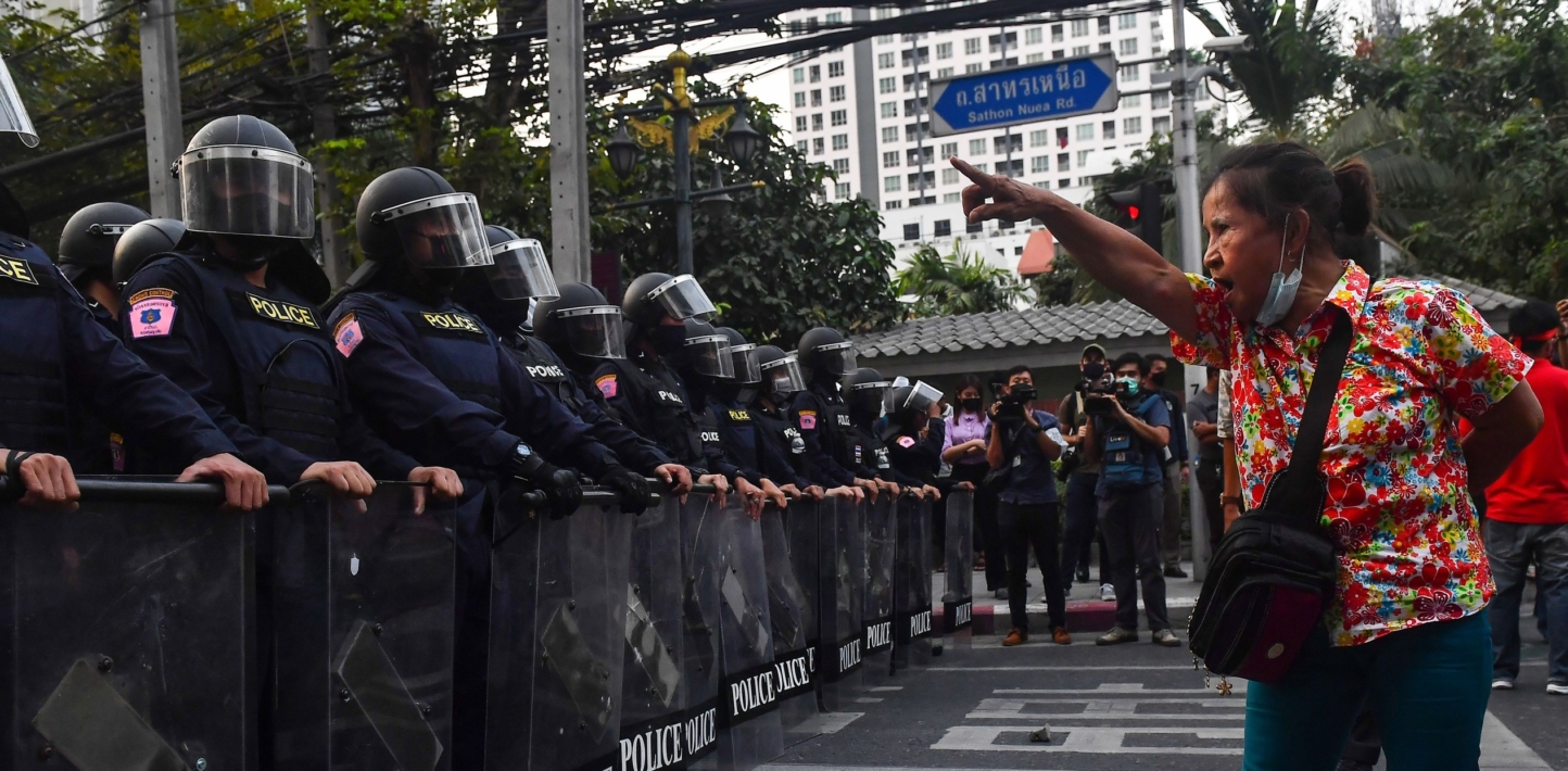 A Thai pro-democracy protester gestures at riot police in Bangkok on February 1, 2021,