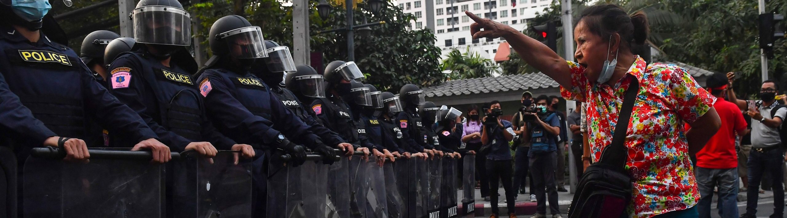 A Thai pro-democracy protester gestures at riot police in Bangkok on February 1, 2021,