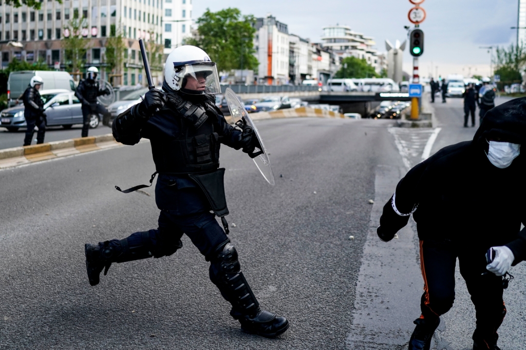 A protestor scuffle with Police officers in riot gear during an anti-racism protest, in Brussels, on June 7, 2020, as part of a weekend of 'Black Lives Matter' worldwide protests against racism and police brutality in the wake of the death of George Floyd, an unarmed black man killed while apprehended by police in Minneapolis, US. (Photo by Kenzo TRIBOUILLARD / AFP) (Photo by KENZO TRIBOUILLARD/AFP via Getty Images)