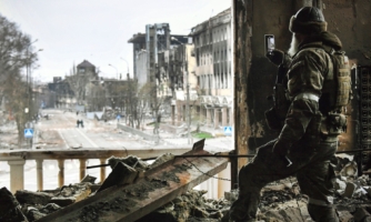 A Russian soldier patrols at the Mariupol drama theatre, bombed last March 16, on April 12, 2022 in Mariupol, Ukraine.