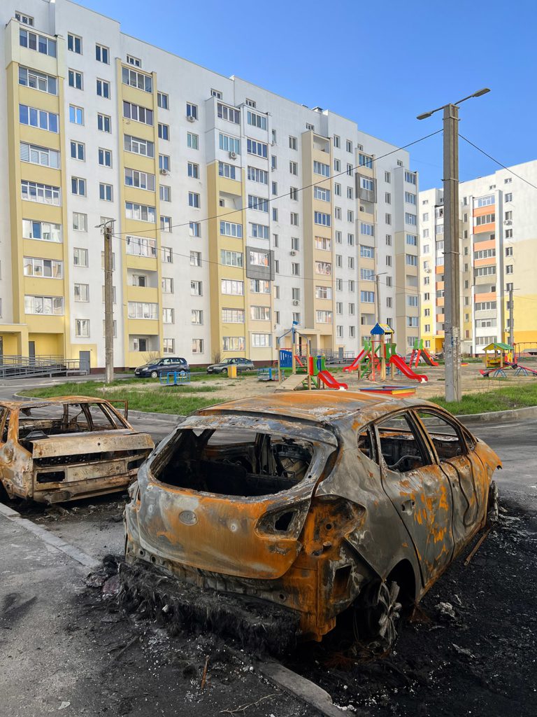 Burnt cars where cluster munitions exploded, killing and injuring several residents in the playground of this housing complex in Myru Street on 15 April.