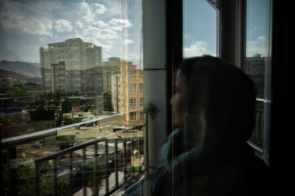 An Afghan woman poses for a portrait in her home.