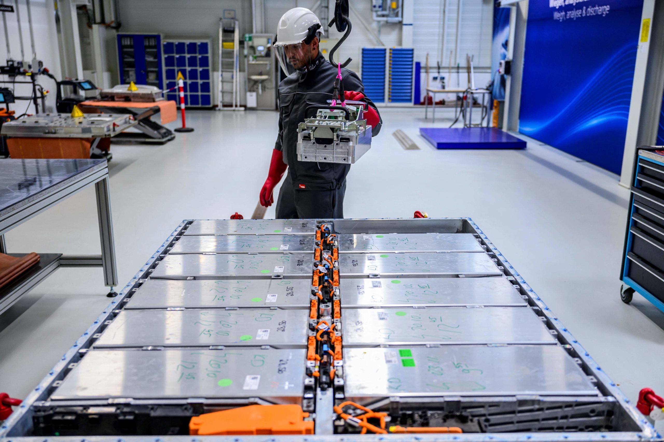 A worker removes a module, containing the battery cells, from a battery pack at Volkswagen's pilot recycling plant for car battery cells at the VW component plant in Salzgitter, north-central Germany