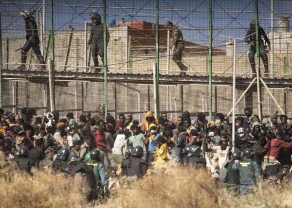 Riot police officers cordon off the area after migrants arrive on Spanish soil and crossing the fences separating the Spanish enclave of Melilla from Morocco in Melilla, Spain, on June 24, 2022.