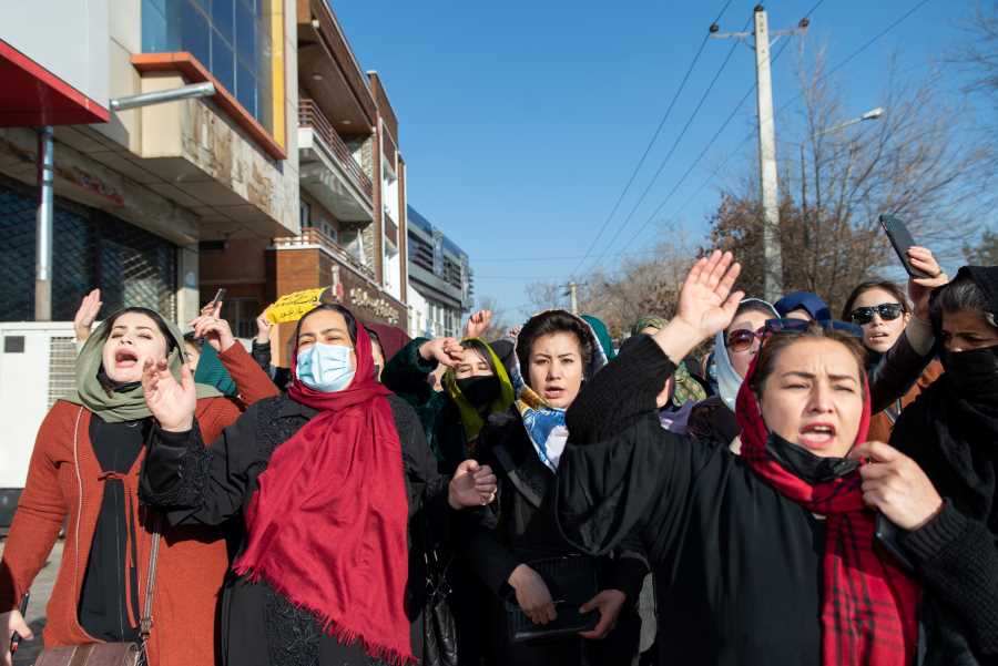 Women marching together, shouting with one arm raised.