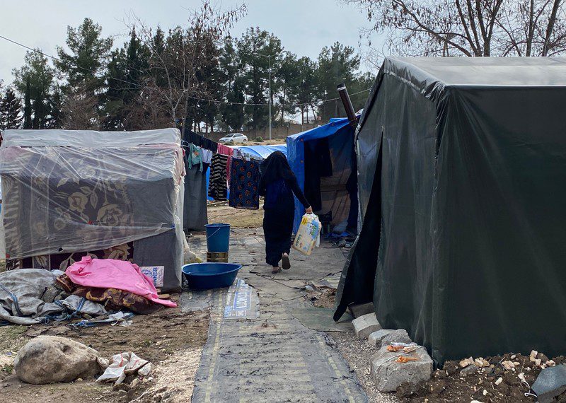 Woman carrying diapers in informal site for Syrian refugees displaced by the earthquakes in Adiyaman, Türkiye March 2023