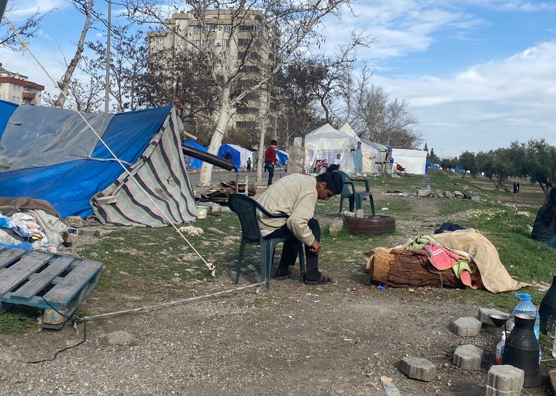 A person with a mental health condition tied from his foot, outside a tent in an informal site for people displaced by the earthquakes in Kahramanmaras, Türkiye March 2023