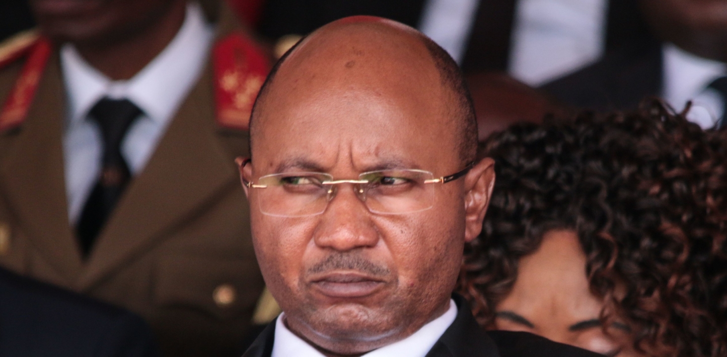 A close up of Alain-Guillaume Bunyoni, Burundi's prime minister His face is serious, he's wearing a black suit with a small Burundi flag on the lapel.