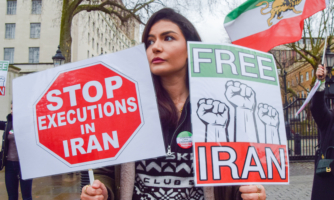 A protester holds 'Stop executions in Iran' and 'Free Iran' placards during the demonstration in London