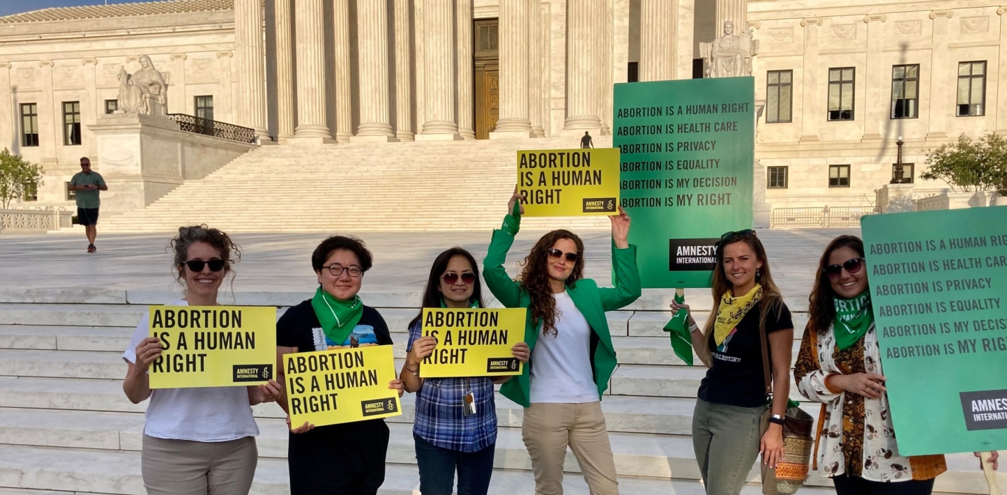 Amnesty International staff in front of the USA Supreme Court hold up signs calling for abortion rights