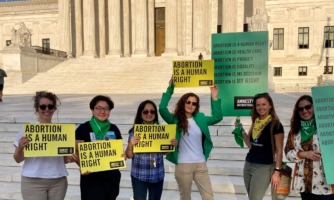 Amnesty International staff in front of the USA Supreme Court hold up signs calling for abortion rights