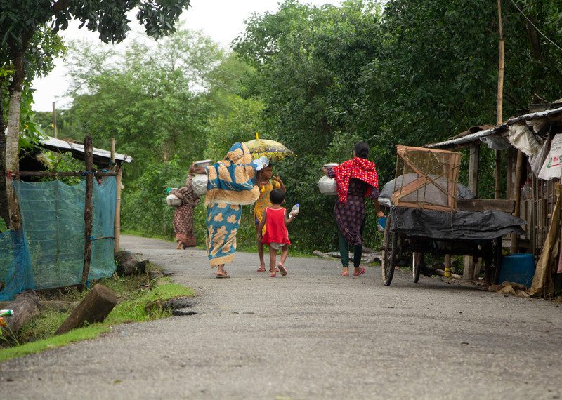 A group of young people carry water. 