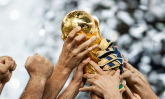 Hands lift the FIFA World Cup trophy aloft