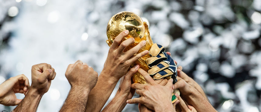 Hands lift the FIFA World Cup trophy aloft