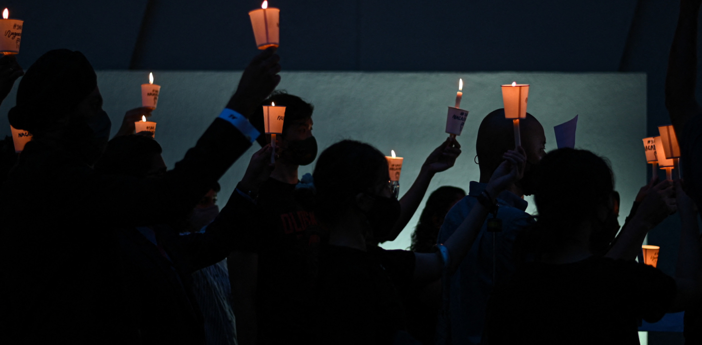 People hold up candles in visual against the death penalty.