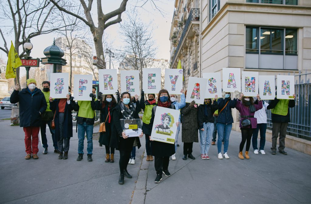 Activistas sostienen una carta que deletrea el nombre de la activista iraní Yasaman Aryani mientras piden su libertad.