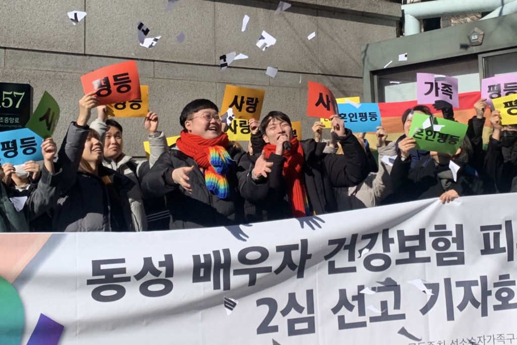 Seong-wook So (izquierda) y Yong-min Kim (derecha) rompen carteles de papel marcados como "discriminación" durante una conferencia de prensa frente al Tribunal Superior de Seúl.