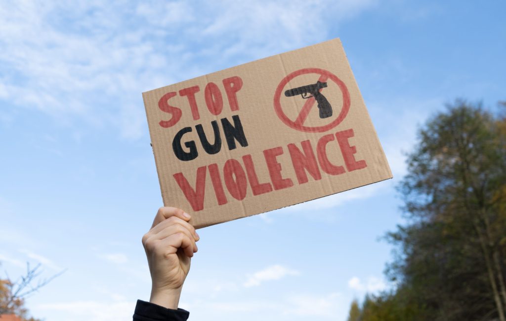 a hand holding a cardboard sign that reads 