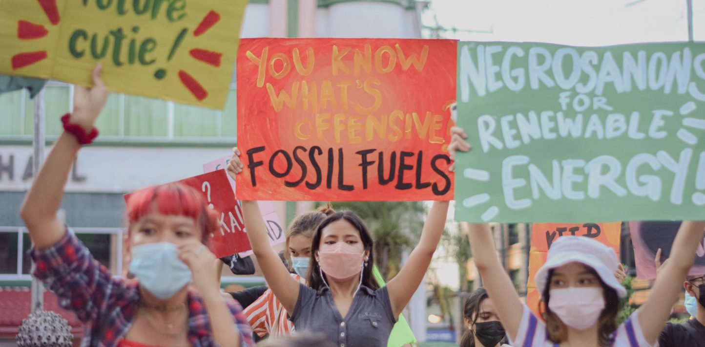 Young people hold up banners in the Philippines about climate change.